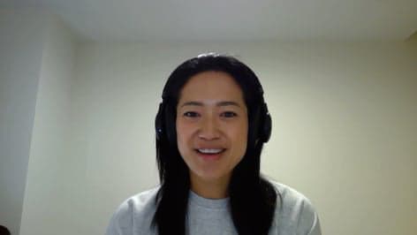 Vicky wearing headphones and smiling at the camera
