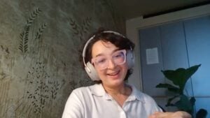 Irina wearing headphones and smiling as she talks about accepting insomnia