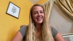 Kelly, a woman with long blonde hair, is sitting in a chair and smiling at the camera as she talks about reclaiming her life from insomnia