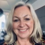 Candice is a woman with shoulder length light blonde hair. She is indoors and smiling at the camera.