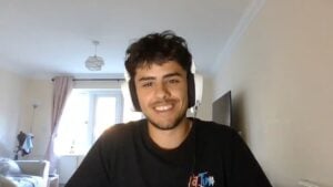 Smiling young man wearing a headset during a video call in a bright room.
